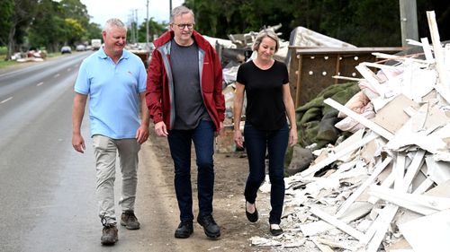 Labor's Anthony Albanese talks to residents Brett and Leanne Bugg outside their flood-wrecked home in Murwillumbah