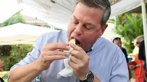 LNP leader Tim Nicholls enjoyed a sausage after voting. (AAP)