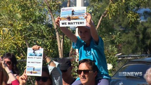The protestors are calling for smart drum linkes along shark attack hotspots. (9NEWS)