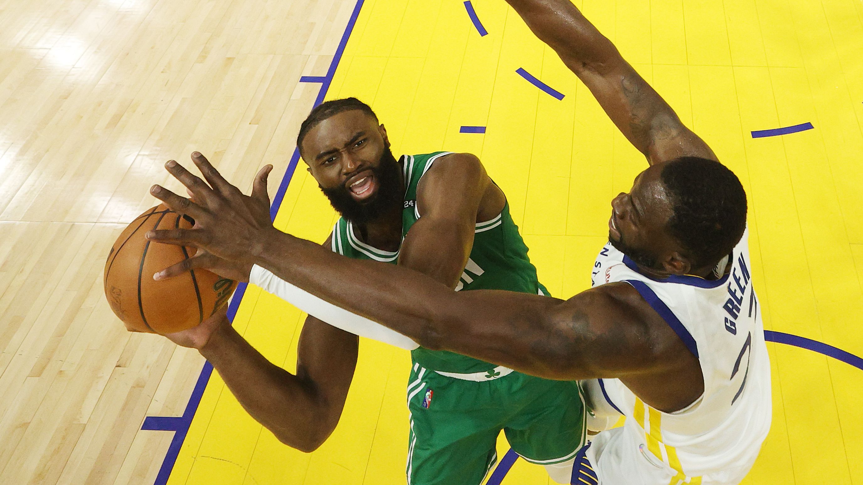 Boston&#x27;s Jaylen Brown shoots the ball against Golden State&#x27;s Draymond Green.