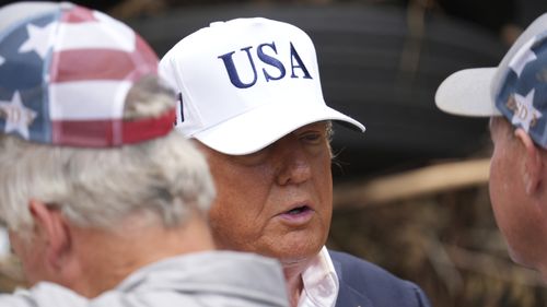 President Donald Trump, center, greets first responders as he observes flood damage in Kerrville, Texas, Friday, July 11, 2025. (AP Photo/Jacquelyn Martin)
