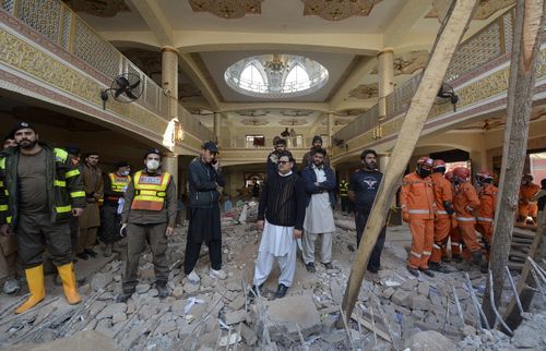 Rescue workers gather as they conduct an operation to clear the rubble and search for bodies at the site of Monday's suicide bombing.