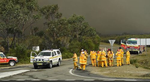 9NEWS cameraman Jayden Webster has captured fire crews working to control the Jervis Bay blaze. (Twitter)