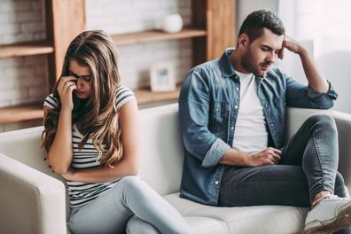 Stock image of a couple looking visibly upset and sitting separately