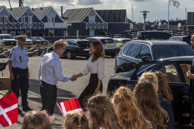 Princess Mary shakes hands with host during royal engagement.