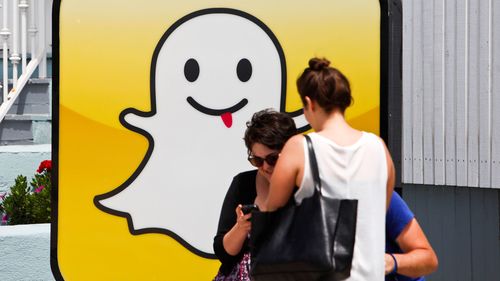 People take pictures in front of the Snapchat Inc. headquarters at Venice Beach in Los Angeles.