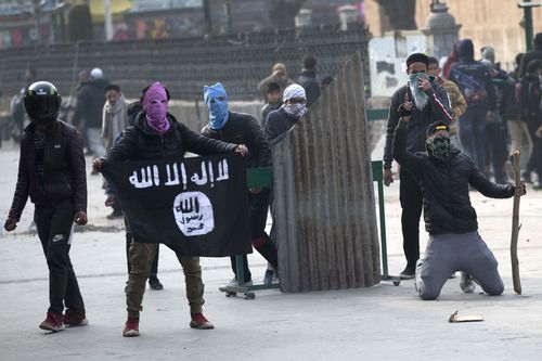 A Kashmiri protester shows Islamic state flag as others clash with Indian policemen during a protest in Srinagar, Indian controlled Kashmir on December 7.