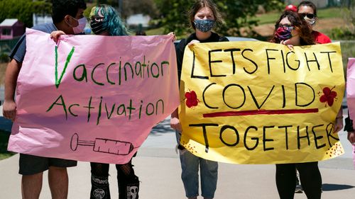 San Pedro High School students hold vaccination signs at a school-based COVID-19 vaccination event for students 12 and older.