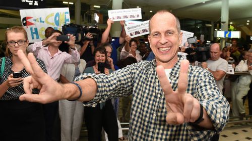 Peter Greste flashes the peace sign upon his arrival in Brisbane. (AAP)