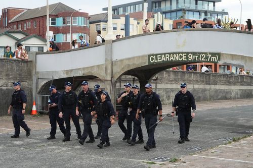 Gli agenti di sicurezza spazzano un'area a Bondi Beach a Sydney, domenica 21 dicembre 2025, in vista di una cerimonia per celebrare la Giornata nazionale di riflessione per le vittime e i sopravvissuti alla sparatoria di Bondi del 14 dicembre.