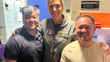 Coast Guard Lt. Katy Caraway reunites with survivors Phong Le, left, and Luan Nguyen.
