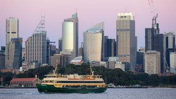 Sydney welcomes a brand new day as the first rays of light hit the buildings in the CBD, as seen from Bradleys Head, Mosman. The Manly Ferry makes it&#x27;s from journey Circular Quay to Manly.