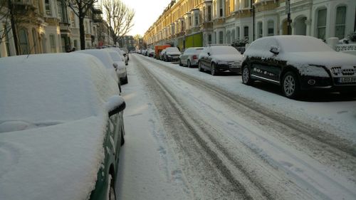 Snow covers cars in London. (AAP)