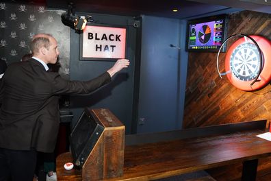 Prince William, Prince of Wales takes part in a game of interactive darts in the 180 Club during a visit to The Rectory during their visit to Birmingham on April 20, 2023