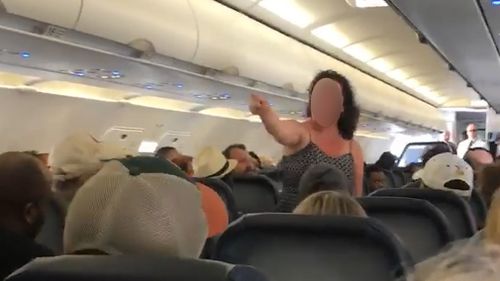 A frightened passenger has captured a woman's profanity-ridden rant aboard a grounded flight moments before she was led away by police. Picture: Facebook/Chianti Washington