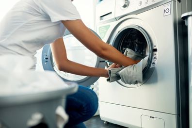 Shot of a young woman doing her laundry at home