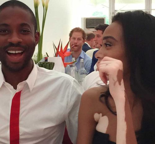 Tongue-poking Prince Harry photobombs model