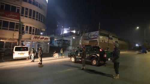 Afghan security officials take up positions near the hotel attack. (AAP)