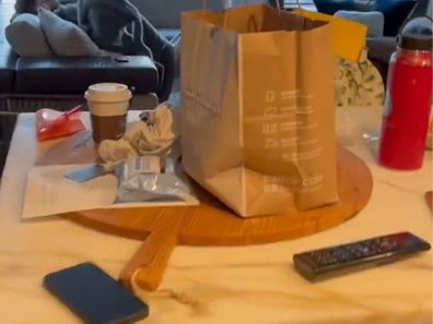 McDonald's paper bag and other items lying on a counter in a messy way