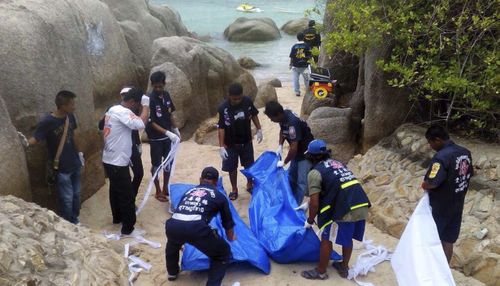 Thai officers walk near bodies of two British tourists on a beach on Koh Tao island in September 2014. (AAP)