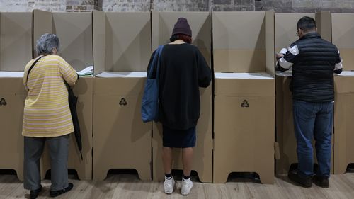 People cast their ballots during early voting for the seat of Wentworth at Oxford Street Mall on May 20, 2022 in Sydney, Australia. Independent Allegra Spender is standing for the seat of Wentworth against Liberal incumbent Dave Sharma. The Australian federal election will be held on Saturday 21 May 2022. (Photo by Brook Mitchell/Getty Images)