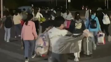  In this photo taken from video footage and released by Hangpai Xingyang, people with suitcases and bags are seen leaving from a Foxconn compound in Zhengzhou in central China&#x27;s Henan Province in October 2022.