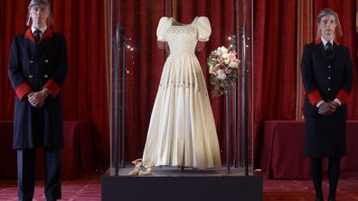 Two wardens stand by Princess Beatrice's wedding dress, designed by the renowned British fashion designer Sir Norman Hartnell and loaned to by Queen Elizabeth II, on display at Windsor Castle in Windsor, England, Wednesday, Sept. 23, 2020