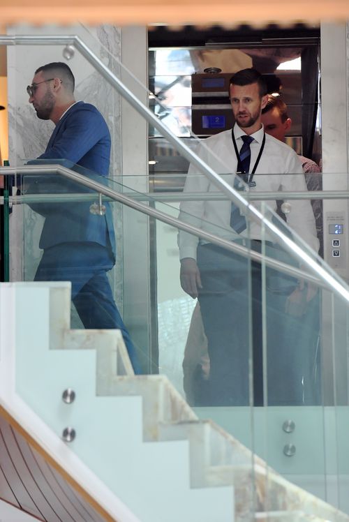 Salim Mehajer (left) is seen hoping out of his lift with detectives after he returned home as police continue to raid his home. (AAP)