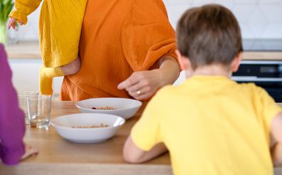 Woman giving children breakfast