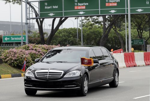 North Korean leader Kim Jong-un is driven in car with flags flying as the motorcade heads out of Singapore Airport.