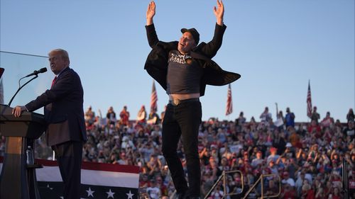 Elon Musk jumps on the stage as Republican presidential nominee former President Donald Trump speaks at a campaign rally at the Butler Farm Show, Saturday, Oct. 5, 2024, in Butler, Pa. 
