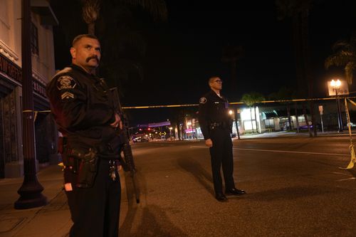 Two police officers stand guard near a scene where a shooting took place in Monterey Park.