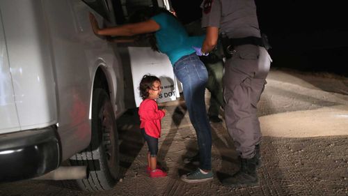  A two-year-old Honduran asylum seeker cries as her mother is searched and detained in Texas. (Getty)