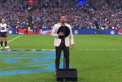 Robbie Mortimer singing national anthem 