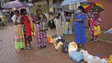 Women wait in a queue to buy kerosene in in Colombo, Sri Lanka, Saturday, June 11, 2022. 