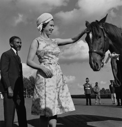 Queen Elizabeth II pats the head of a horse, watched by Emperor Haile Selassie (1892 - 1975) during her royal tour of Ethiopia, February 1965. 