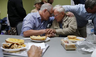 Prime Minister Scott Morrison is seen comforting 85-year-old Owen Whalan of Half Chain road in Koorainghat Sunday, November 10, 2019. (AAP Image/Darren Pateman) NO ARCHIVING