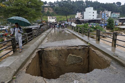 A bridge over Bagmati River lies damaged due to floods caused by heavy rains in Kathmandu, Nepal, Saturday, Sept. 28, 2024. (AP Photo/Gopen Rai)