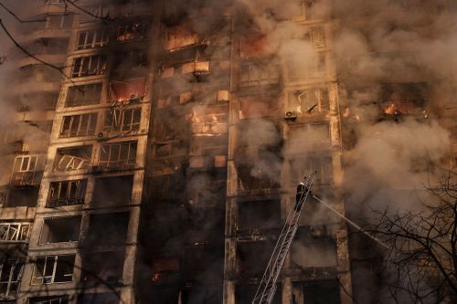 Les pompiers éteignent les incendies dans un immeuble touché par des bombardements à Kiev