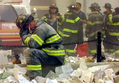 Exhausted firefighter Gerard McGibbon, of Engine 283 in Brownsville, Brooklyn, prays after the World Trade Center buildings collapsed. 