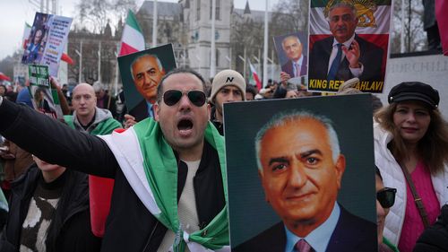 I manifestanti a Londra portano manifesti di Reza Pahlavi.