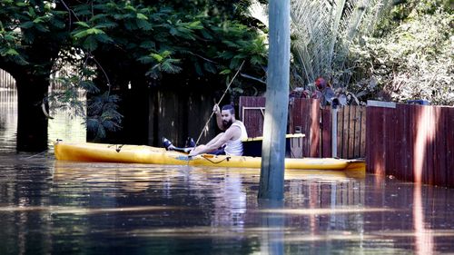 A man delivers supplies to stranded residents in Fairfield in Brisbane.