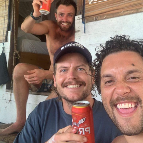 Elliot Foote enjoying a bear with two friends to celebrate his survival after disappearing in the Indonesian ocean.