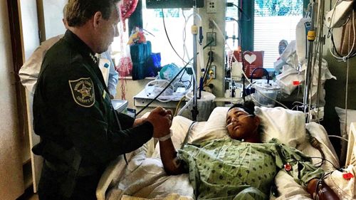 Sheriff Scott Israel, holding the hand of Anthony Borges, 15, a student at Marjory Stoneman Douglas High School. (AAP)