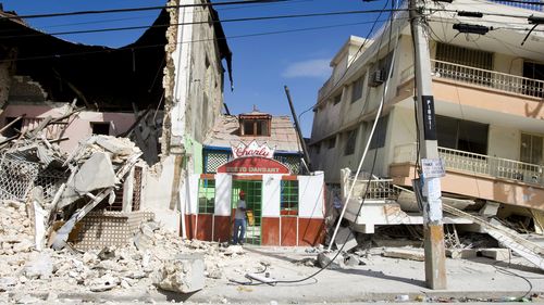 A man exits a restaurant after he looked for his belongings after the 2010 Haiti earthquake.