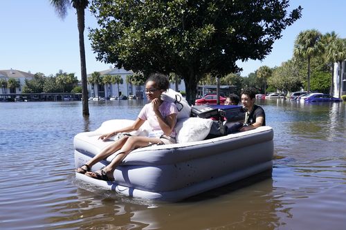 Les étudiants de l'Université de Floride centrale utilisent un matelas gonflable lorsqu'ils évacuent un complexe d'appartements près du campus qui a été totalement inondé par la pluie de l'ouragan Ian, le vendredi 30 septembre 2022, à Orlando, en Floride