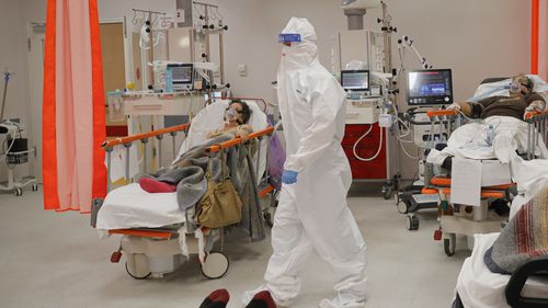 Personalul medical asistă pacienții în camera de urgență, care a fost transformată în unitate CODIV-19 din cauza numărului mare de cazuri, la Spitalul Bagdasar-Arseni din București, România, marți, 12 octombrie 2021. România a raportat, marți, 17.000 de persoane. cazuri noi.  Infecții cu COVID-19 și 442 de decese, cel mai mare număr de infecții cu coronavirus și decese într-o singură zi de la începutul pandemiei, în timp ce sistemul de sănătate al țării se luptă să facă față unei creșteri puternice a noilor cazuri (AP Photo/Andreea Alexandru)