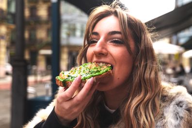 Young woman eating breakfast in a cafe