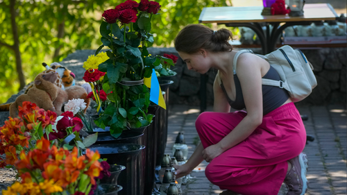 A woman lights a candle at a shopping center, after a rocket attack in Kremenchuk, Ukraine, Tuesday, June 28, 2022. (AP Photo/Efrem Lukatsky)