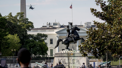 A presidential helicopter, the Washington Monument, and the White House are visible behind a statue of Andrew Jackson in Lafayette Park with the word Killer spray painted on its base after protesters tried to topple the statue near Black Lives Matter Plaza, Tuesday, June 23, 2020, in Washington. (AP Photo/Andrew Harnik)